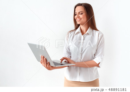 Modern technology. Woman standing isolated on white browsing internet on laptop joyful 48891181
