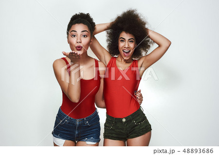 Feeling happy! Cute afro american woman in casual clothing sending an air kiss while while standing 48893686