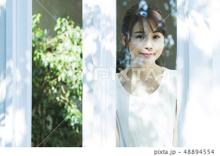 女性　朝　起床　窓越し　ビューティー　ライフスタイル 48894554