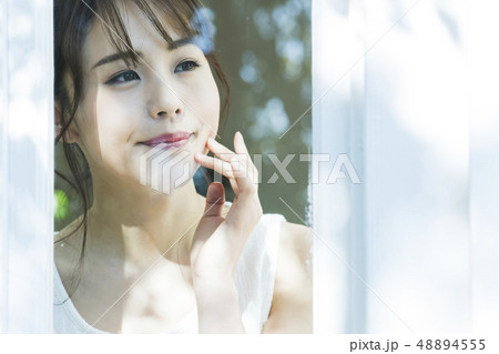 女性　朝　起床　窓越し　ビューティー　ライフスタイル 48894555