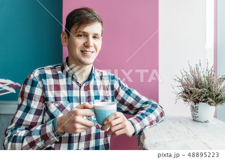 Man's hand holds the phone, the guy sitting 48895223