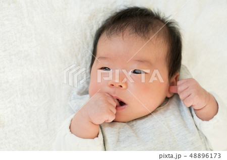 赤ちゃん 指しゃぶり 男の子 乳児の写真素材