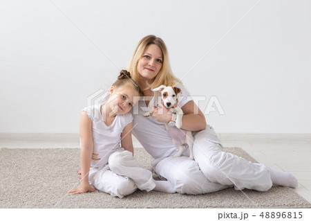 people, family and pets concept - mother and daughter sitting on the floor with puppy Jack Russell people, family and pets concept - mother and daughter sitting on the floor with puppy Jack Russell 48896815
