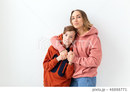 Mothers day, children and family concept - teen boy hugging his mom on white background Mothers day, children and family concept - teen boy hugging his mom on white background 48898771