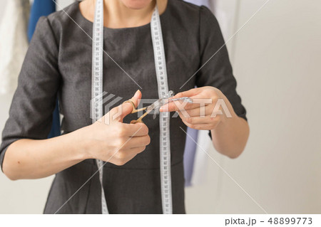 Dressmaker, fashion designer and tailor concept - Seamstress and her hands close up in workshop 48899773