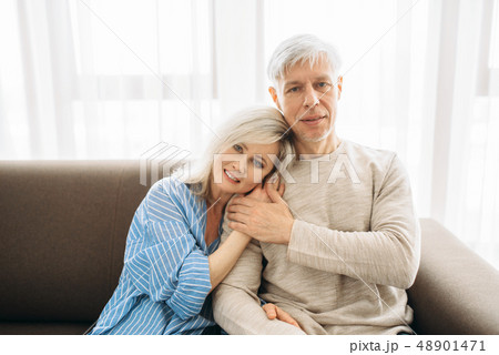 Mature husband and wife sitting on couch and hugs 48901471