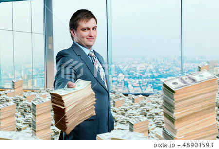 Young businessman holding out a wad of money 48901593