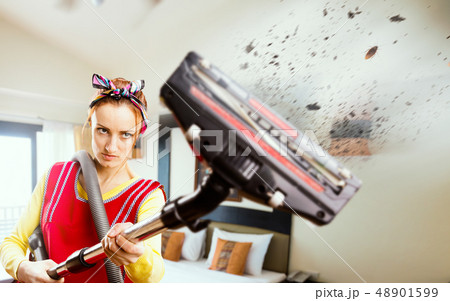 Angry housewife in apron with vacuum cleaner 48901599