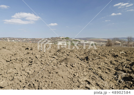 Plowed field in spring time with blue sky Plowed field in spring time with blue sky 48902584