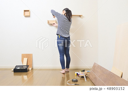 DIY ウォールシェルフを取り付ける女性 48903152