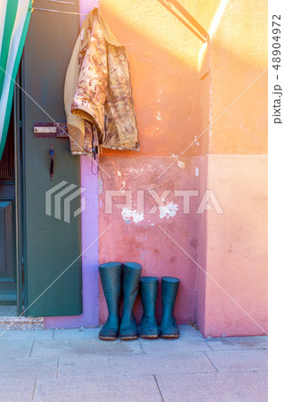Two pairs of rubber boots on walkway 48904972