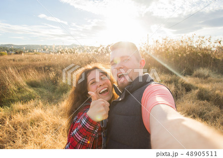 Travel, vacation and holiday concept - Happy couple taking selfie over beautiful landscape 48905511