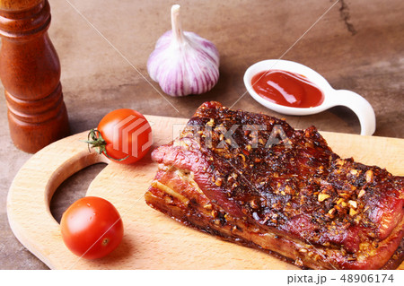 Sliced grilled pork ribs barbecue Striploin steak with chimichurri sauce and tomatoes on cutting 48906174