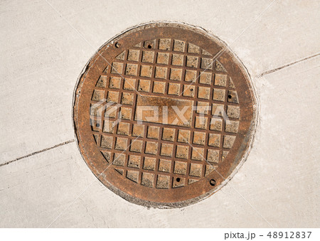 Cast iron manhole hatch on concrete pavement. Cast iron manhole hatch on concrete pavement. 48912837