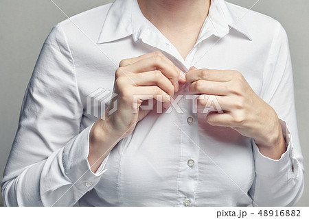 Business woman in white blouse unbuttoning shirt 48916882