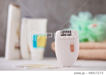 Epilator and wax strips on background with towel 48917273