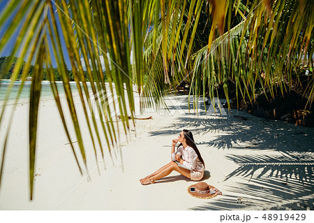 woman travel and work remotely in tropics on beach 48919429