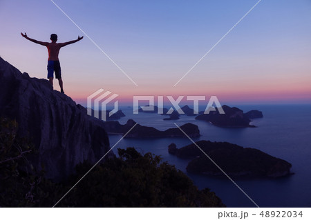 Man standing on the top of the mountain looking 48922034