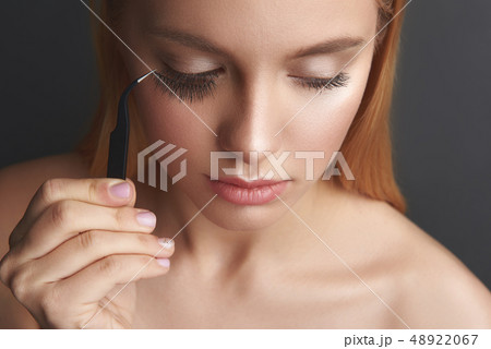 applying false eyelashes