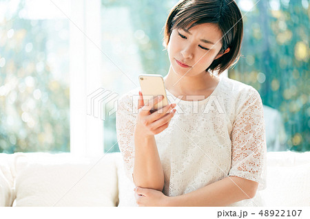 スマホ 悩む 女性の写真素材