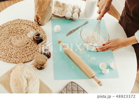 Close up of kitchen table and woman kneading dough 48923372