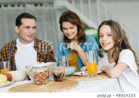 Selective focus of the girl having breakfast with parents Selective focus of the girl having breakfast with parents 48924233
