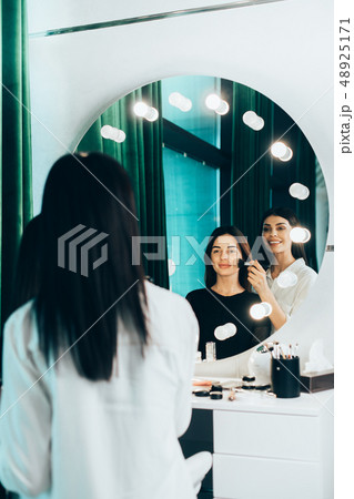 Reflection of stylist and her client in makeup studio 48925171