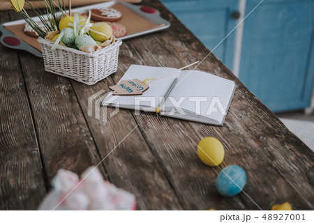 Opened copybook laying on easter decorated table 48927001