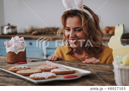 Happy funny woman look at Easter cookies Happy funny woman look at Easter cookies 48927163