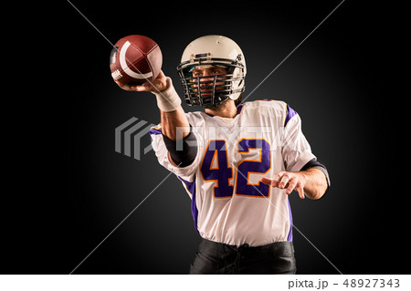 American football player in uniform with the ball is preparing to make a pass. American football American football player in uniform with the ball is preparing to make a pass. American football 48927343
