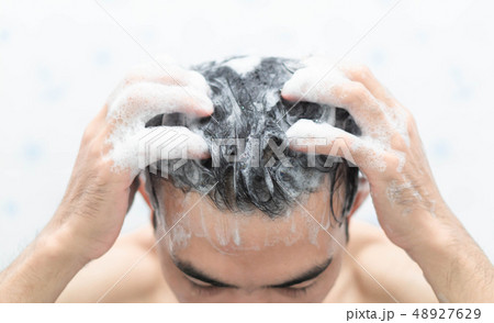 Closeup young man washing hair with with shampoo Closeup young man washing hair with with shampoo 48927629