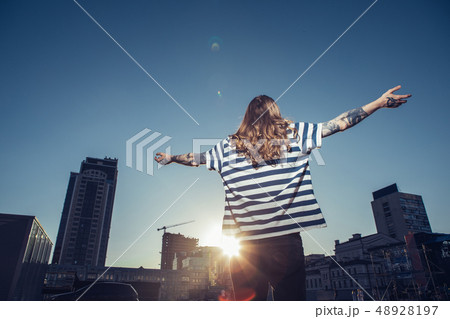 Rear view of along haired man enjoying sunbeams 48928197