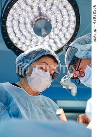 Portrait of professional surgeons during surgery on a blue background. Concept surgery, medicine Portrait of professional surgeons during surgery on a blue background. Concept surgery, medicine 48928556