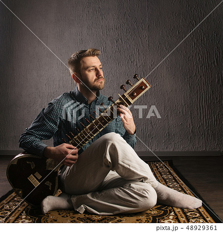 Portrait of a European man playing the sitar Portrait of a European man playing the sitar 48929361