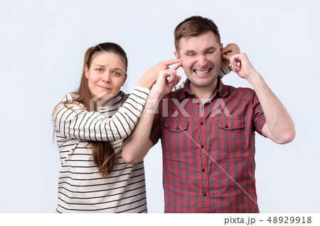 woman closing her husband ears. she wants to keep something in secret. 48929918