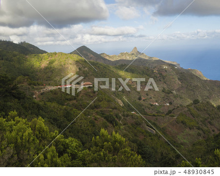 view on Monte Taborno with green hills, houses and blue sky white clouds in anaga mountain, tenerife 48930845