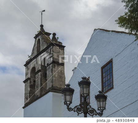 Traditional church stone bell tower and street lamp in Puerto de la cruz, Spain, Canary islands Traditional church stone bell tower and street lamp in Puerto de la cruz, Spain, Canary islands 48930849