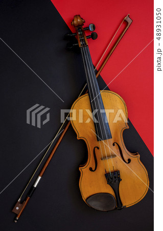 Violin and bow on a red and black background 48931050
