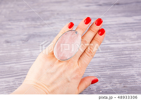 A silver ring on a hand with rose quartz 48933306