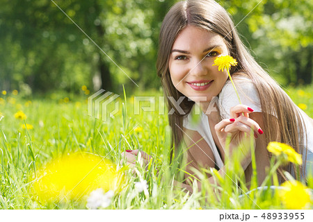 Woman laying on grass in park Woman laying on grass in park 48933955