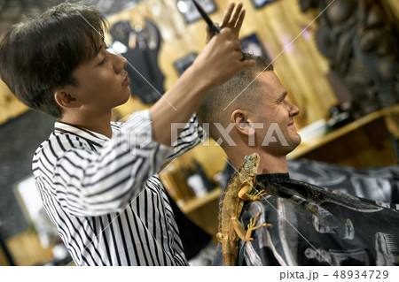 Man is cutting his hair in asian barbershop Man is cutting his hair in asian barbershop 48934729