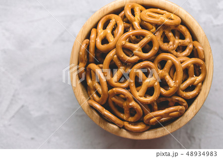 Traditional salty mini pretzels in wooden bowl Traditional salty mini pretzels in wooden bowl 48934983