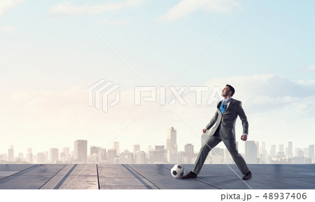 Businessman kicking ball 48937406