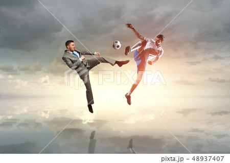 Businessman kicking ball Businessman kicking ball 48937407