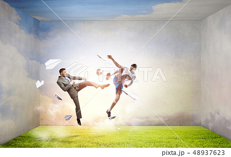 Businessman kicking ball Businessman kicking ball 48937623