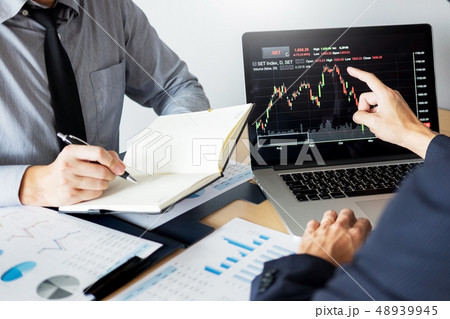 Stock traders looking at finance analysis Stock traders looking at finance analysis 48939945
