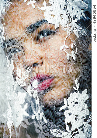 portrait of beauty young afro woman through white lace, like new bride under veil close up 48940994