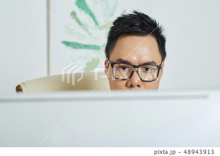 Face of designer checking his work on computer screen 48943913