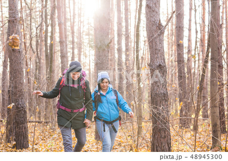 adventure, travel, tourism, hike and people concept - smiling couple walking with backpacks over adventure, travel, tourism, hike and people concept - smiling couple walking with backpacks over 48945300