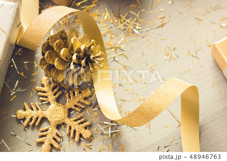 Golden shimmer Christmas decorating items on wood 48946763